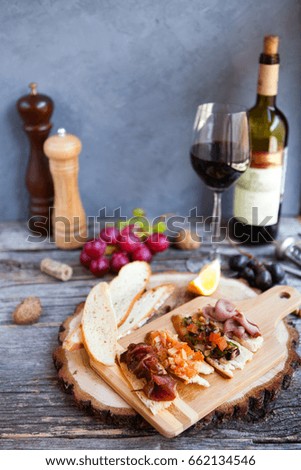 Wine snack set. Glass of red and white wine, grape, cheese, over rustic wooden background. Top view, copy space, horizontal composition.  
