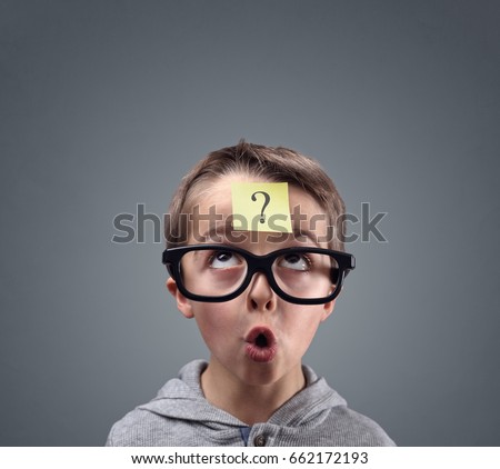 Confused boy thinking with question mark on sticky note on forehead Royalty-Free Stock Photo #662172193