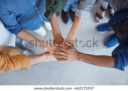 Solidarity and unity conept. Cropped shot of business partners holding their hands together expressing their agreement. True friends keeping their hands together swearing always help each other Royalty-Free Stock Photo #662175937