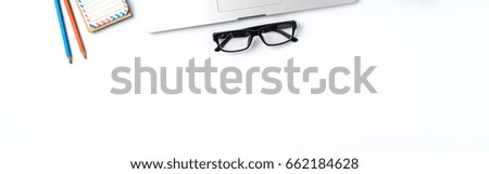 Office desktop with laptop, glasses and accessories