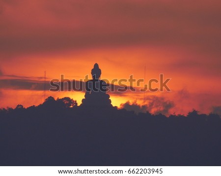 sunset behind big buddha statue on hilltop at Phuket , Thailand