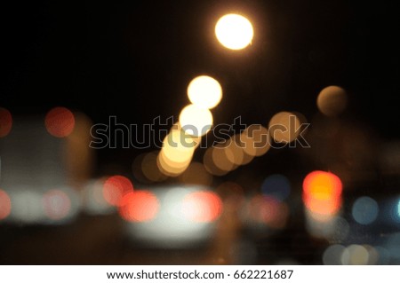 Bokeh of moving cars in the downtown, blurred in the night time.