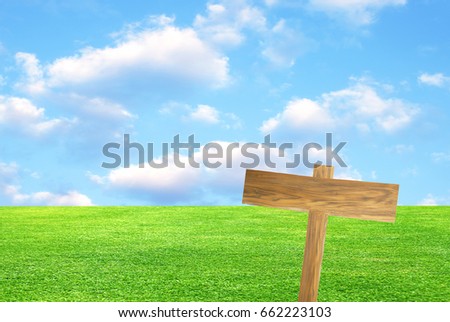 Road sign in green grass field over blue sky background
