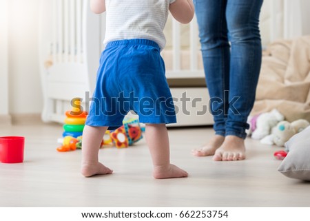 Closeup image of 10 months old baby boy making first steps at home Royalty-Free Stock Photo #662253754