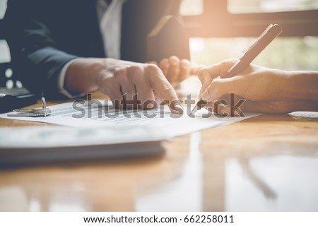 Businessman and estate agent signing a document for house deal, vintage filter effect Royalty-Free Stock Photo #662258011