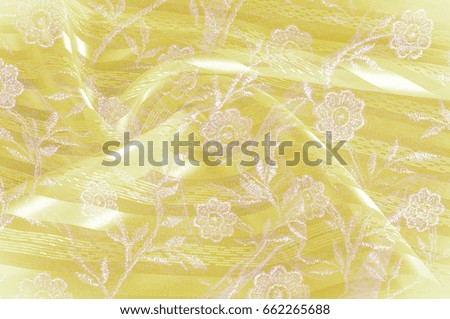 Texture, background, pattern. Yellow cloth fabric fabric fabric on background. Close-up of lacy floral fabric on yellow