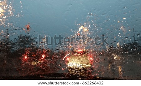 Raining at the evening made very heavy traffic jammed. Raindrops on the glass so much made everything outside blur.