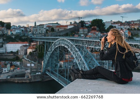Young woman taking pictures in the downtown of Porto, Portugal.