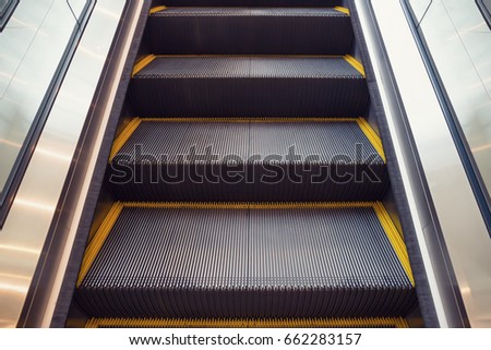 Escalator or moving staircase. Consist of step, handrail. Powered by electric motor for carry people between floor of indoor building i.e. shopping mall, airport, underground, office, metro and subway