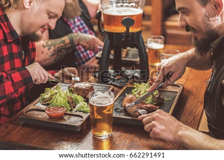 Joyful men eating in pub