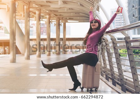 Happy woman traveller in airport walkway with travel bag or luggage. Concept of woman happy travel lifestyle.
