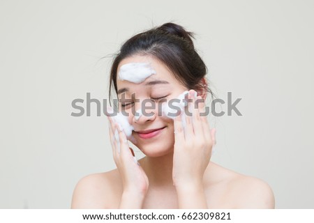 lovely cute Asian girl enjoy with her skincare product that she apply on her face to make healthy young skin Royalty-Free Stock Photo #662309821
