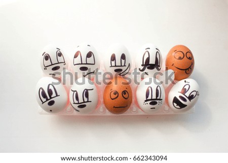 Groupmates concept. Eggs in cells with a painted face looking up. black and white. on a white background. Photo for your design

