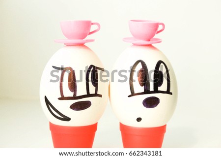 Tea drinking concept. two friends. The egg is pleased with the painted face. on a white background. Photo for your design