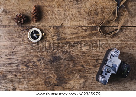 Retro camera and compass on a wooden background. Travel concept