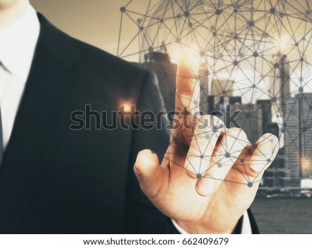 Businessman pointing at abstract polygonal sphere on city background. Connectivity concept