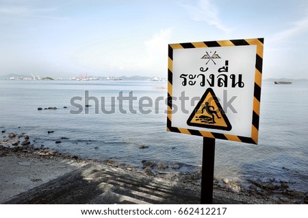 Sign of Beware Slippery Surface in Thai Language on Seaside                                                               