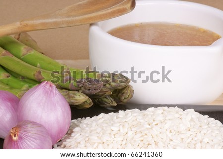Ingredients for the typical italian dish "risotto con gli asparagi": rice, asparagus, shallot and vegetable stock.