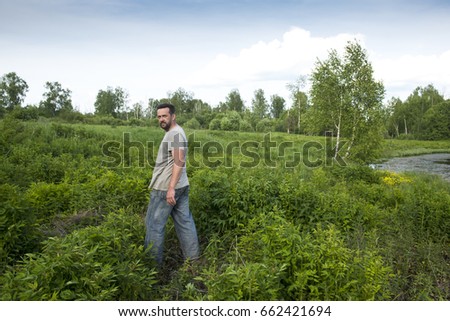 The adult man is standing on the forest edge. Real people