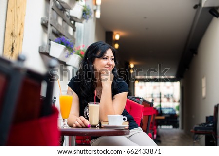 Young woman in restaurant sitting outside