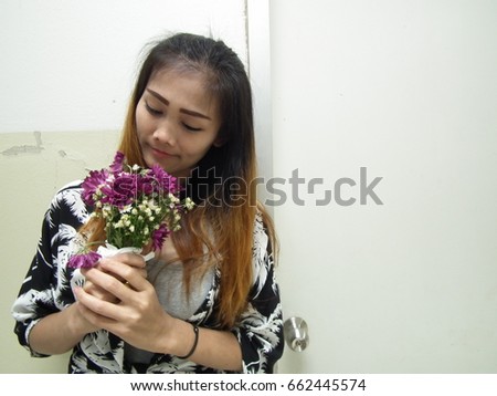Beautiful woman smiling and holding flowers. 
