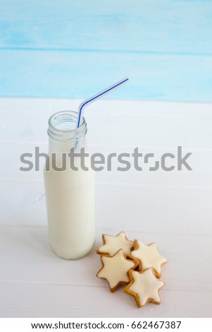 chip cookies and a school milk bottle with a straw on a white wooden table
