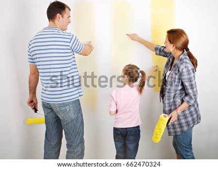 Family of three choosing colors to paint a room. Each one pointing on a different color shade.