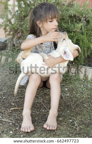 Portrait of 10 year old girl with a puppy golden retriever puppy.