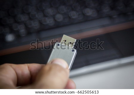 Flash Drive in Hand and Notebook
