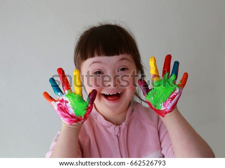 Cute little girl with painted hands. Isolated on grey background.