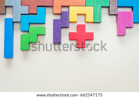 Different colorful shapes wooden blocks on beige background, flat lay. Geometric shapes in different colors, top view. Concept of creative, logical thinking or problem solving. Copy space. Royalty-Free Stock Photo #662547175