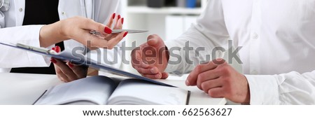 Female doctor hand hold silver pen and showing pad. Physical agreement form signature, disease prevention, ward round reception, consent contract sign, prescribe remedy, healthy lifestyle concept