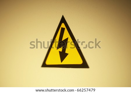 High voltage sign hung on yellow background.