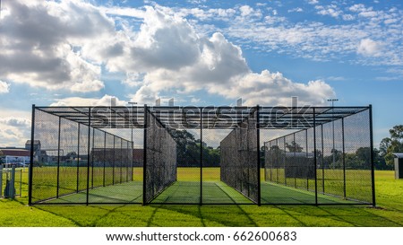 A row of cricket practice nets on green grass and with a blue sky in Melbourne, Victoria, Australia Royalty-Free Stock Photo #662600683