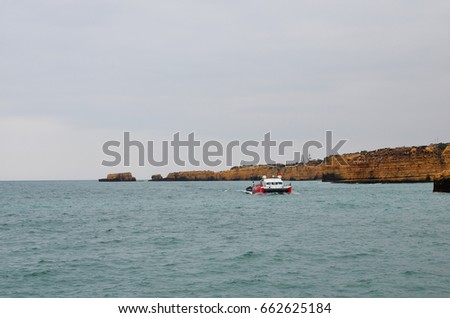 Recreational tourist boat to visit the caves in sandstone escarpments in Algarve