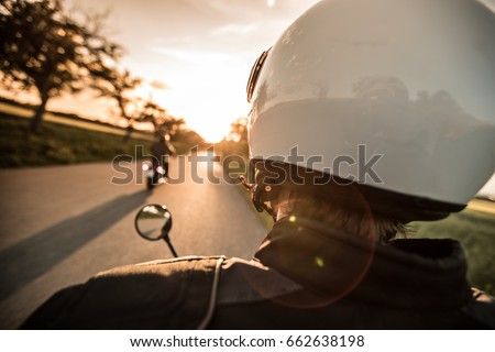 Man riding sportster motorcycle on countryside during sunset. Royalty-Free Stock Photo #662638198