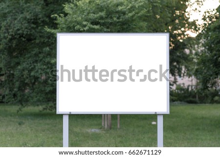 Blank ad space sign infront of trees in a park