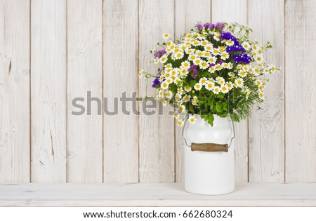 Wild chamomile flowers bouquet on table over wooden planks background