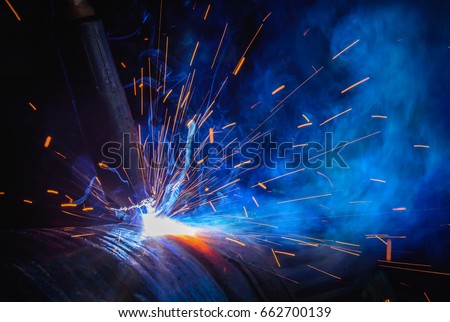 Welding steel structures and bright sparks in steel construction industry. Royalty-Free Stock Photo #662700139