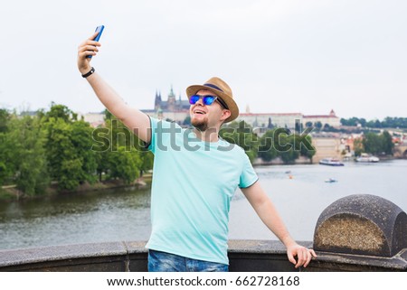 Handsome man is taking a selfie outdoor - caucasian people - nature, people, lifestyle and technology concept.