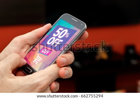 Man with a smartphone with a 50% discount advertising on the screen. Marketing, ecommerce, cell phone publicity.