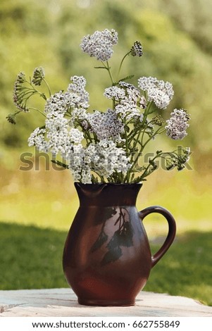 Vase with wild flowers achillea