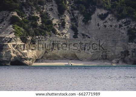 Scenic View Of Anchored Boat On Ionian Sea Near Beach And Astonishing Cliffs During Summer
