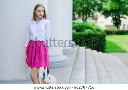 Outdoor summer portrait of a young attractive lady walking in the park
