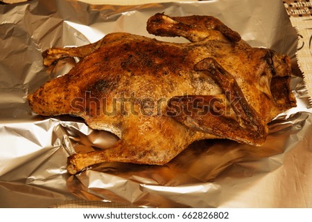 A whole roast duck on a sheet of tinfoil