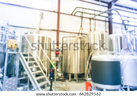 Blurred image modern beer plant (brewery) with stainless steel brewing equipment of kettle, vessel, tub, pipe. Row of tanks in microbrewery. Brewery production vat, fermentation interior. Vintage tone