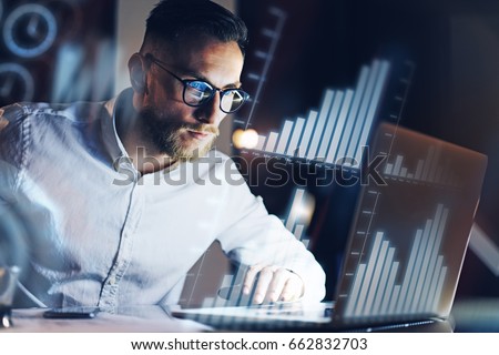 Concept of digital diagram,graph interfaces,virtual screen,connections icon.Young entrepreneur working at modern office on laptop.Man using digital touch pad at night,blurred background.Horizontal Royalty-Free Stock Photo #662832703
