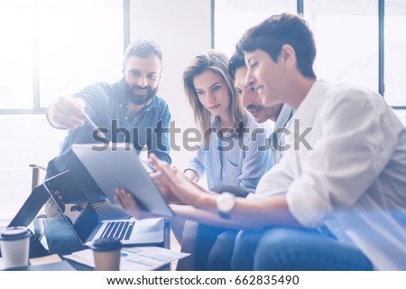 Business meeting concept.Coworkers team working new startup project at modern office.Analyze business documents, using touch tablet.Blurred background.Horizontal. Royalty-Free Stock Photo #662835490
