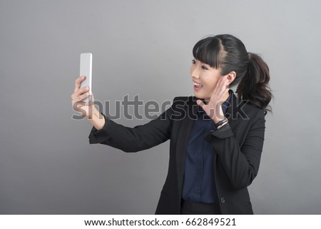 Beautiful business Woman using smartphone on grey background