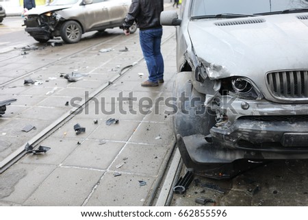 Group car accident with many damages on street, man out of focus at winter
